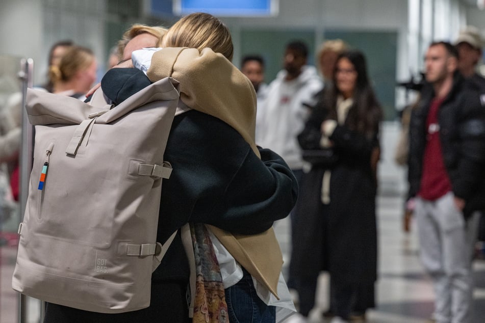 Fluggäste einer Sondermaschine aus Dubai treffen am Flughafen München ein und werden dort von Familie und Freunden begrüßt.