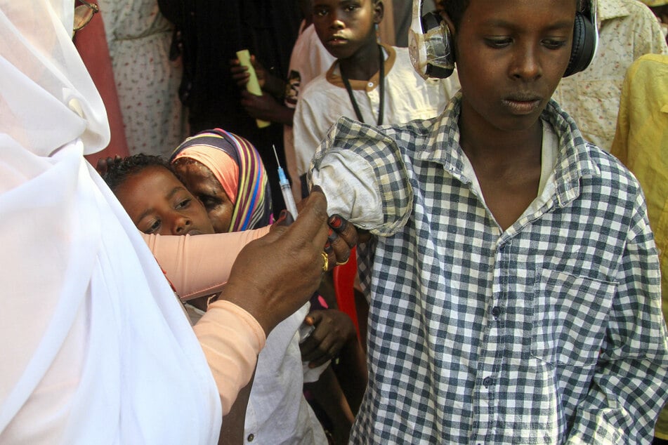 A Sudanese child receives a vaccine shot in Sudan's eastern state of Gedaref on January 22, 2024, during a vaccination campaign against the measles and rubella virus.