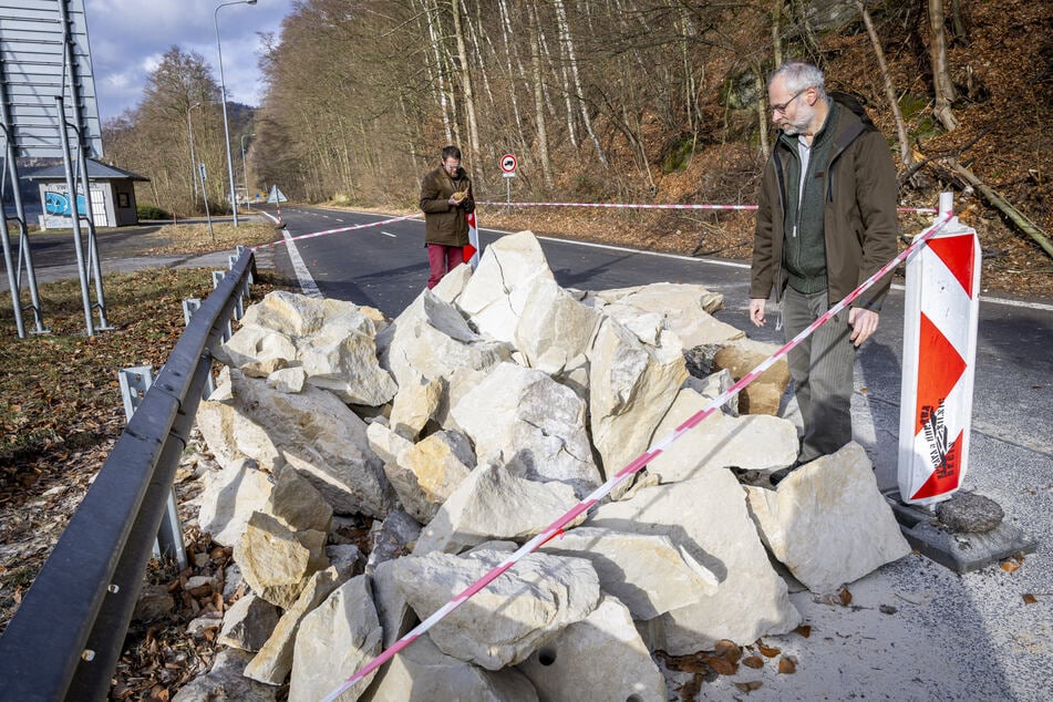 Tomáš Salov (49, r.), Sprecher des Nationalparks Böhmische Schweiz, begutachtet den zerteilten Sandsteinbrocken.
