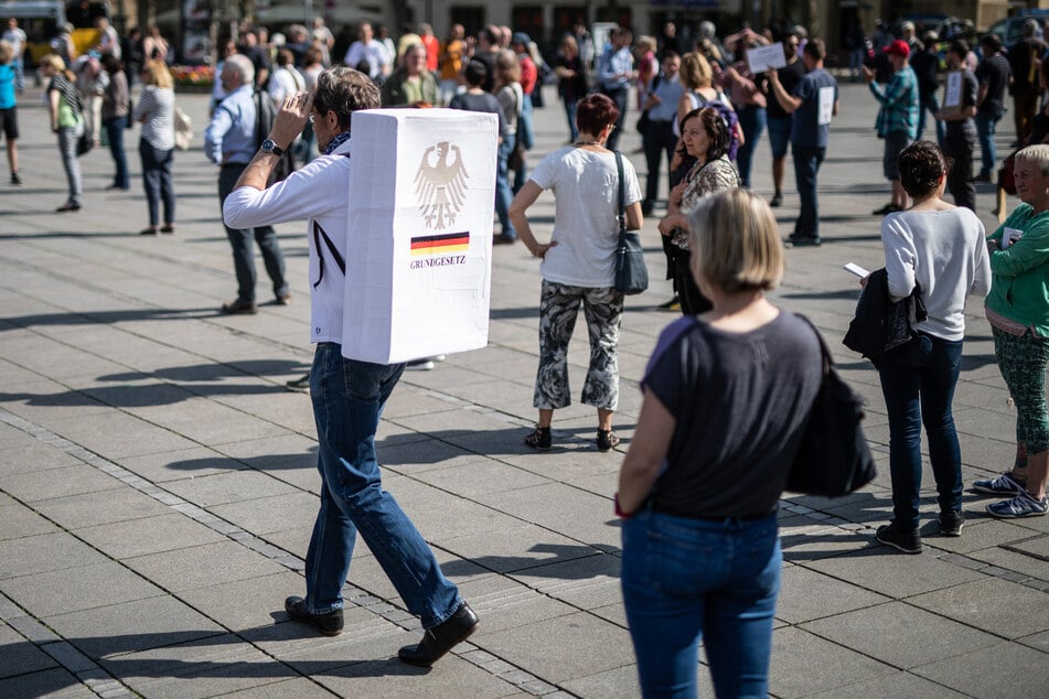 "Grundgesetz" steht auf einem Schild an dem Rücken eines Teilnehmers einer Demonstration gegen die Einschränkungen der Grundrechte in Zeiten der Corona-Krise.