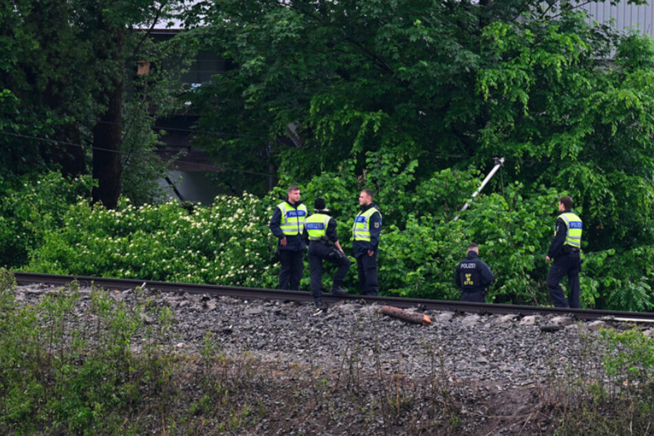 Polizisten suchen auf dem Gleis an der Unfallstelle nach Spuren.