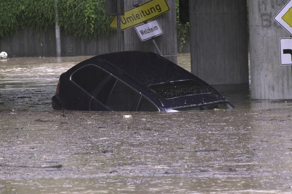 Ein Auto treibt am 23. Juni durch das Hochwasser in einer Unterführung am Bahnhof in Schwäbisch Gmünd. Der Deutsche Wetterdienst erwartet für Montagabend erneut schwere Unwetter in Baden-Württemberg.