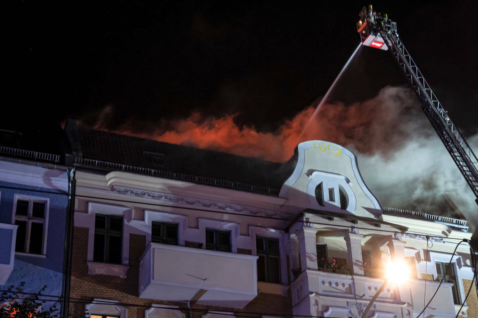 Die Feuerwehr löscht den Brand im Dachgeschoss über eine Drehleiter.
