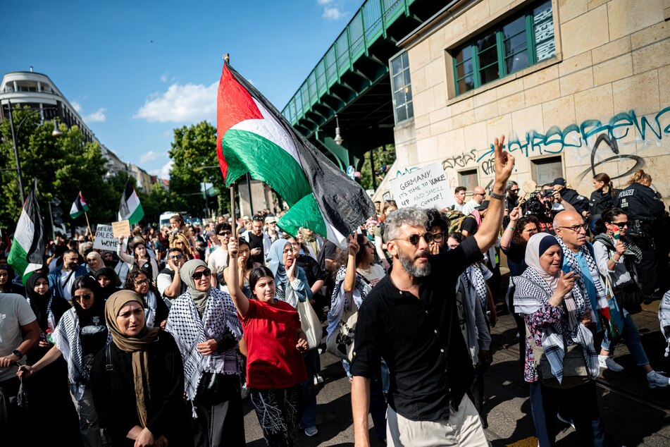 Menschen laufen durch Berlin und fordern "Stoppt den Gaza-Genozid".