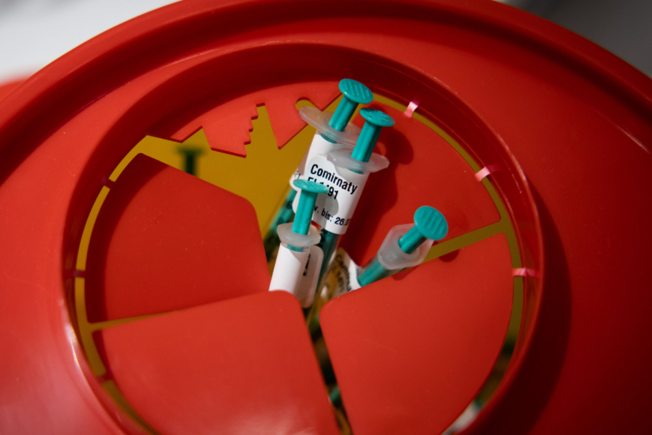 Leere Einwegspritzen, die den Impfstoff gegen das Corona-Virus SARS-CoV-2 von BioNTech/Pfizer enthielten, sind in einem Sammelbehälter in einem Impfraum im Hamburger Impfzentrum zu sehen.