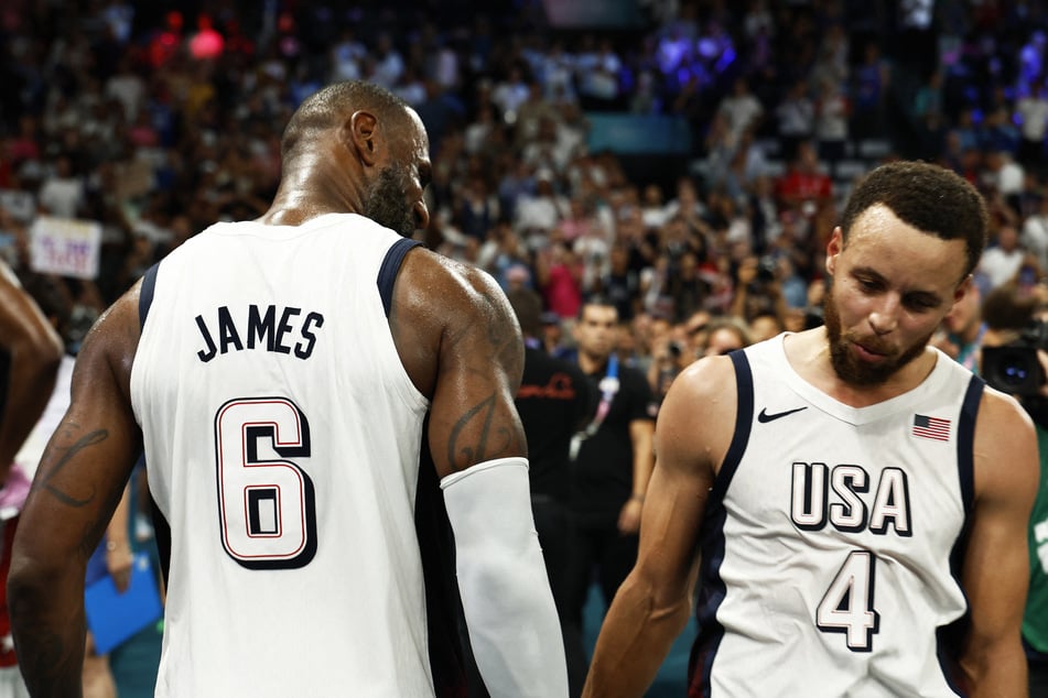 Lebron James (l.) and Stephen Curry of Team USA high five after winning their men's basketball semifinal match against Serbia at the Paris Olympics.