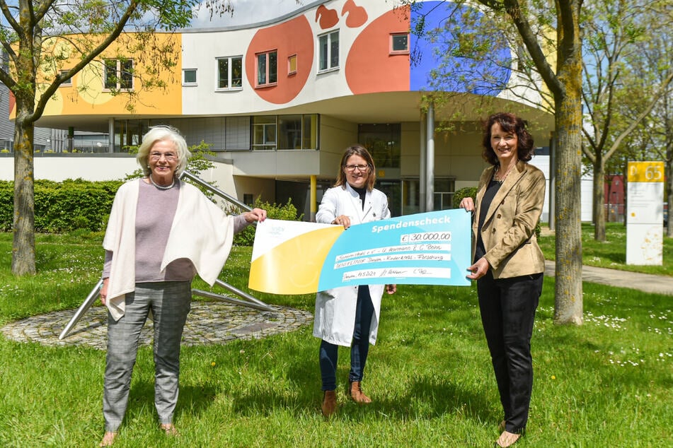 Ursula Herrmann (l.) und Cornelia Bohn (r.) übergeben die Spende an Julia Hauer vom Universitätsklinikum.