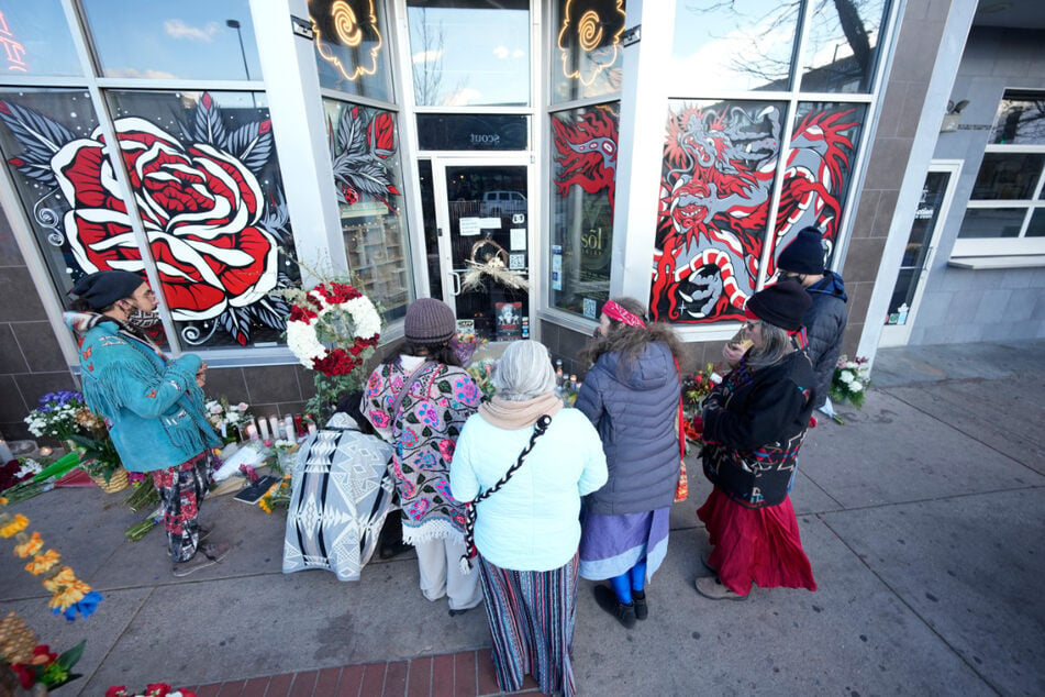Trauernde versammeln sich vor der Tür eines Tattoostudios am South Broadway in Denver.