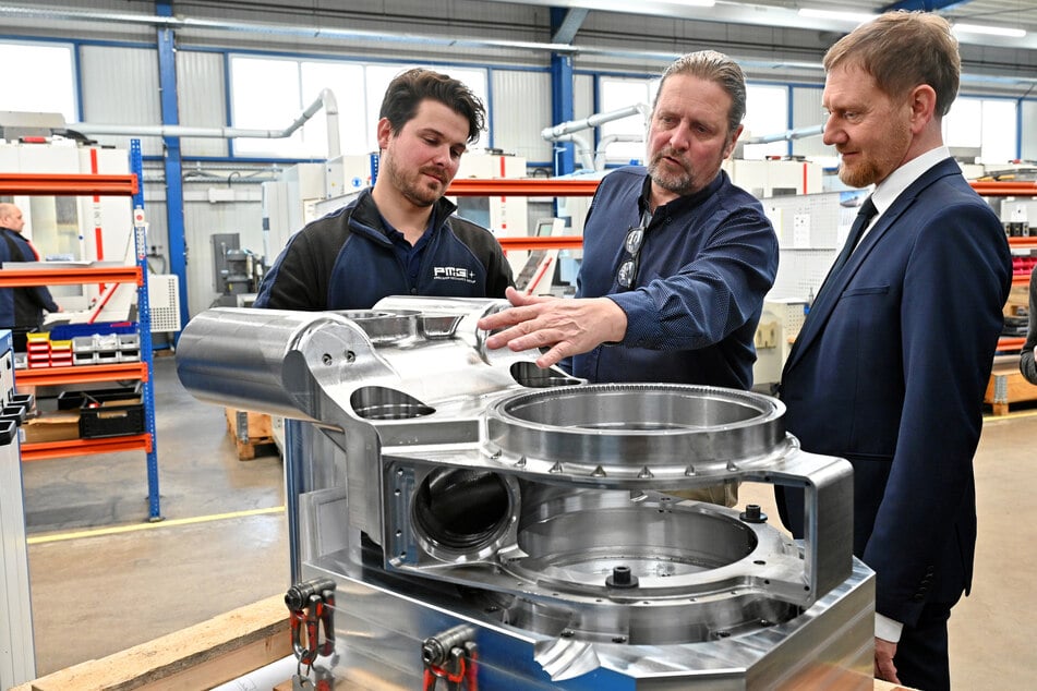 Robert Pätzold (32, l.) und Michael Freudenberg (59) von PMG erläutern Michael Kretschmer (50, CDU, r.), was das Dämpfungssystem kann.
