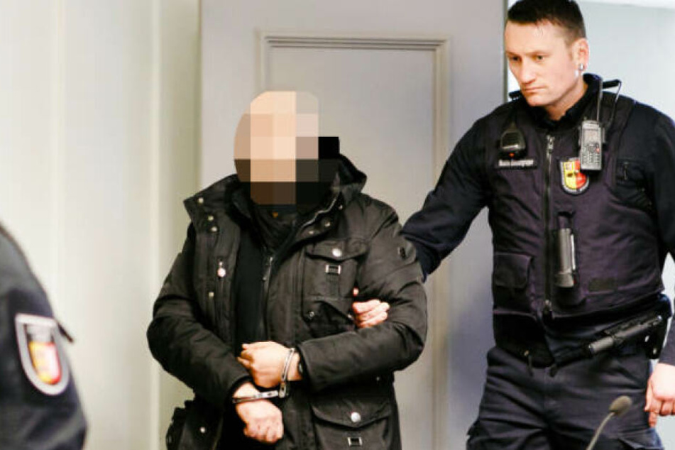 Der Angeklagte wird von einem Justizbeamten in den Gerichtssal des Landgerichts Kiel geführt.
