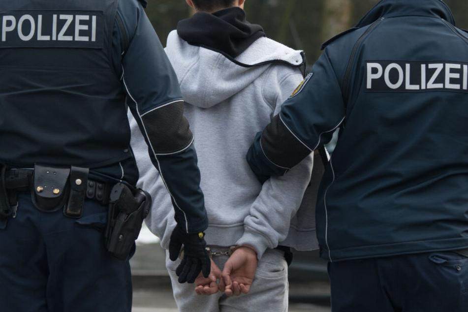 Polizisten führen einen festgenommenen Mann ab. (Symbolbild)