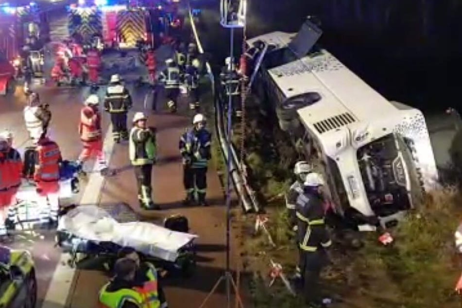 Der polnische Reisebus liegt neben der Fahrbahn. Zahlreiche Rettungskräfte sind im Einsatz.