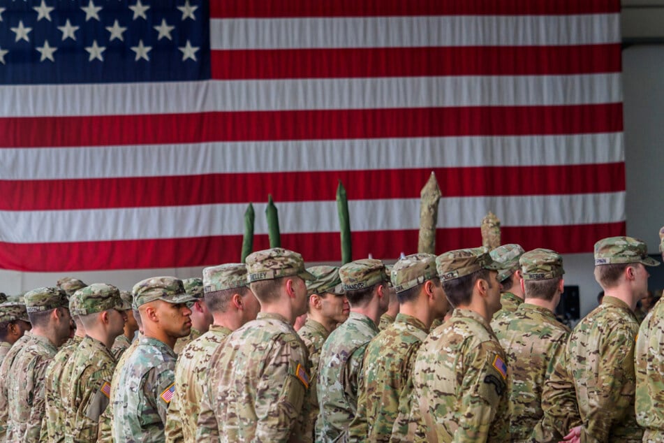 US-Soldaten in Deutschland stehen während einer militärischen Zeremonie vor einer US-Flagge. (Archiv)