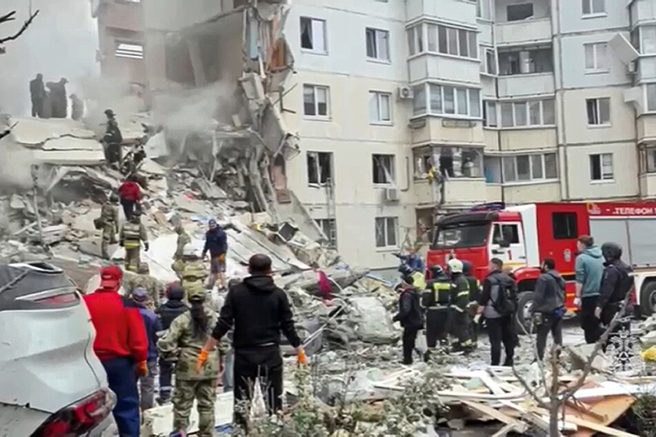 Rettungskräfte kämpfen sich durch die vielen Trümmer des teilweise eingestürzten Wohnblocks in Belgorod.