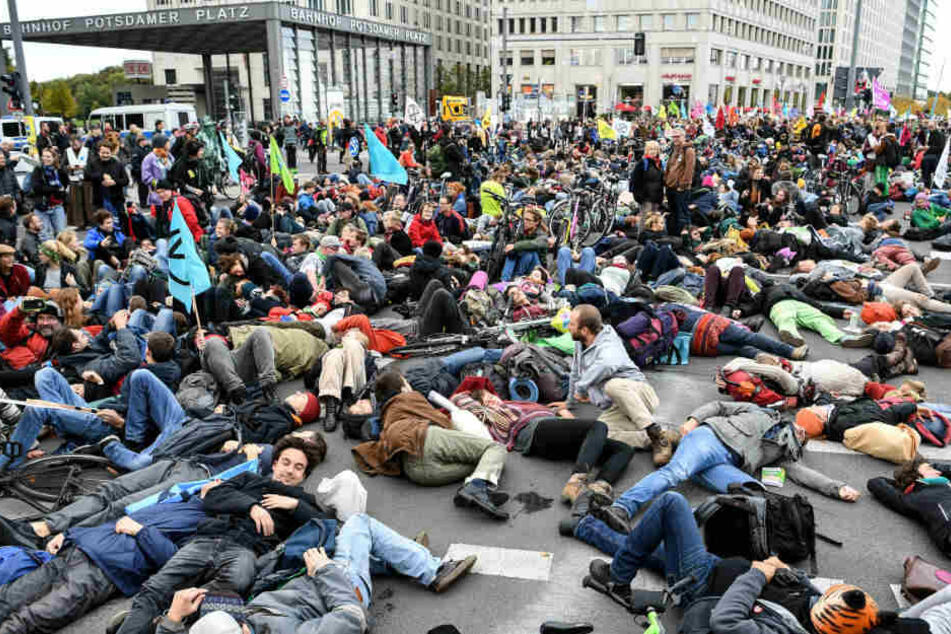 Aktivisten demonstrieren am Potsdamer Platz und legen sich dabei auf den Boden.