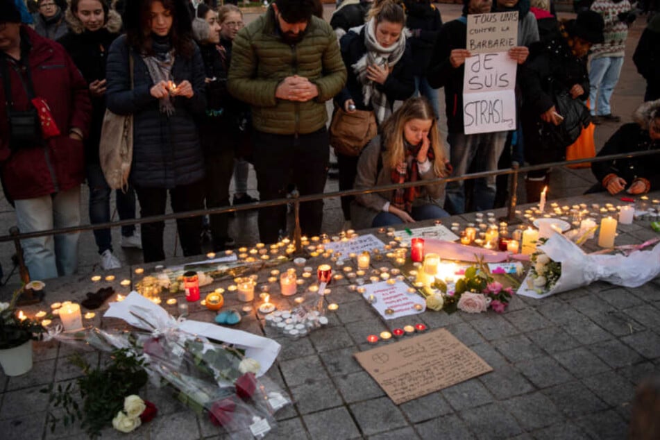 Entsetzen und Trauer nach dem Attentat. Menschen legen in Straßburg Kerzen nieder.