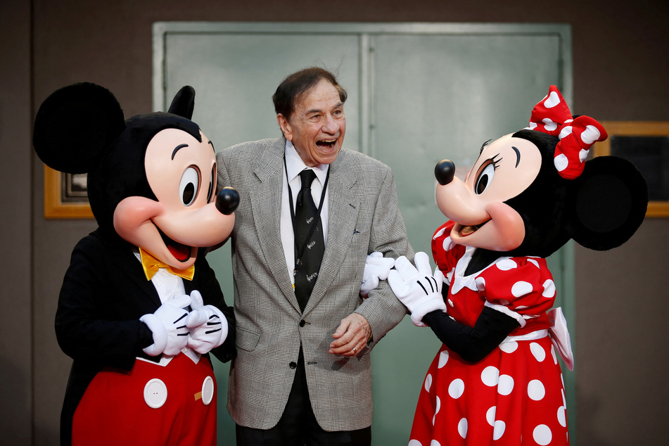 Legendary Disney songwriter Richard M. Sherman poses with Mickie and Minnie Mouse.