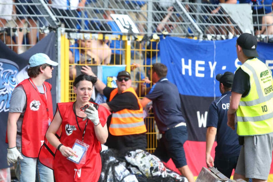Während des Skandal-Spiels stehen Ordne rund Journalisten im Carl-Benz-Stadion vor den Rängen.