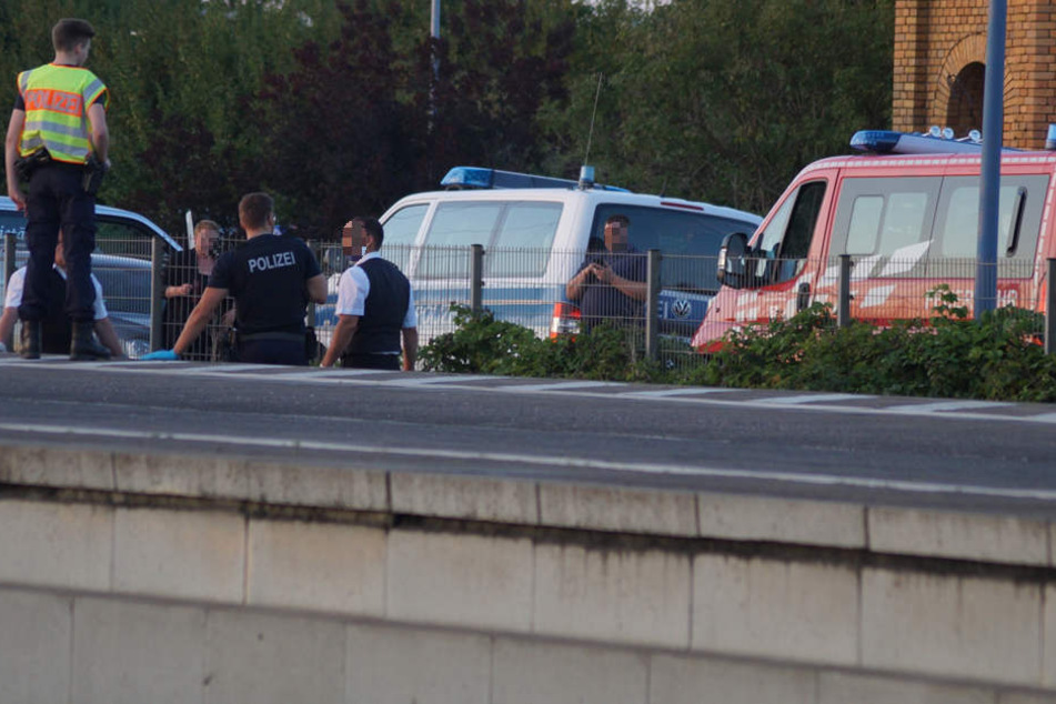 Polizisten stehen an der Unglücksstelle am Bitterfelder Bahnhof. Hier starb eine Frau, die von einem Güterzug erfasst wurde.