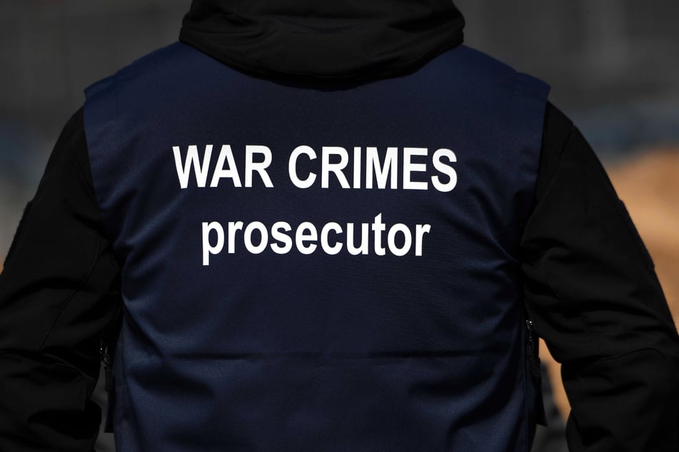 Ein Ermittler eines internationalen Forensik-Teams trägt eine Weste mit der Aufschrift "War Crimes Prosecutor"