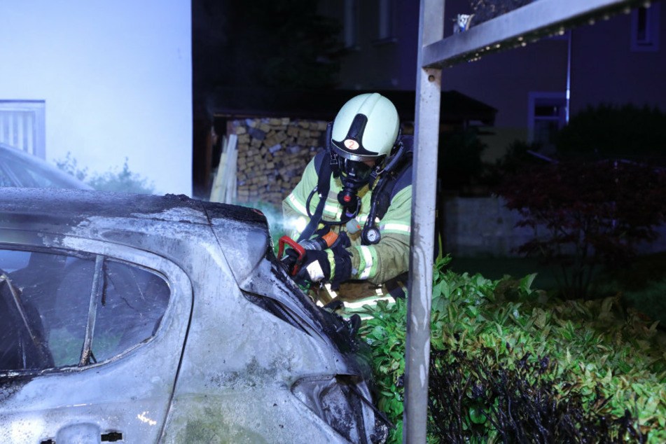 Hoch konzentriert löscht der Feuerwehrmann das Auto.