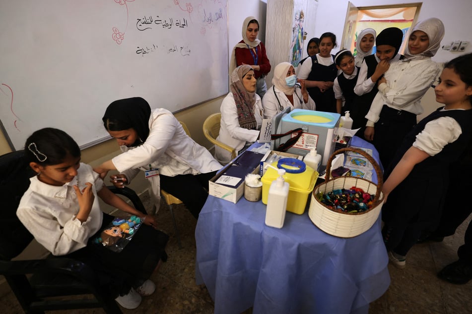 A young girl receives a measles vaccine at a school in Baghdad, on April 14, 2024, part of a vaccination campaign for school students across Iraq.