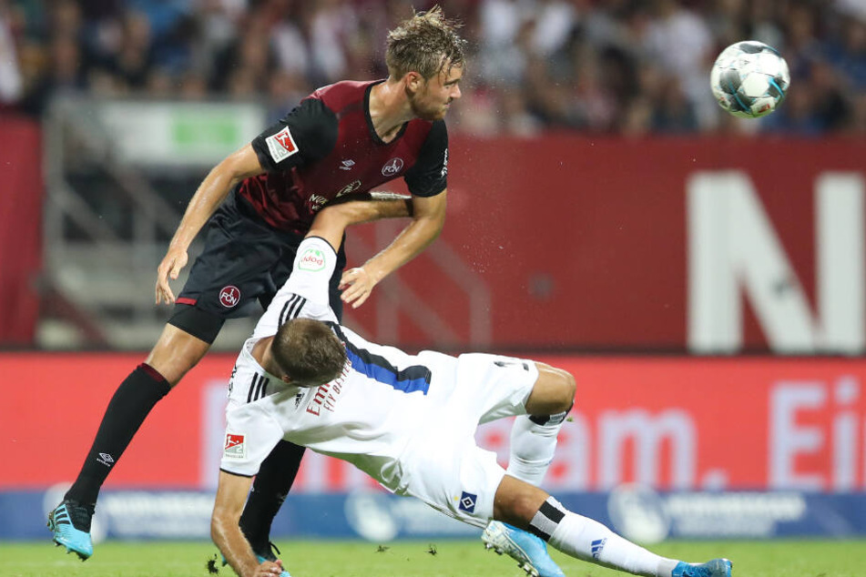 Stürmer Lukas Hinterseer wird bei einem Zweikampf mit Nürnbergs Ansgar Sörensen zu Boden gerammt.