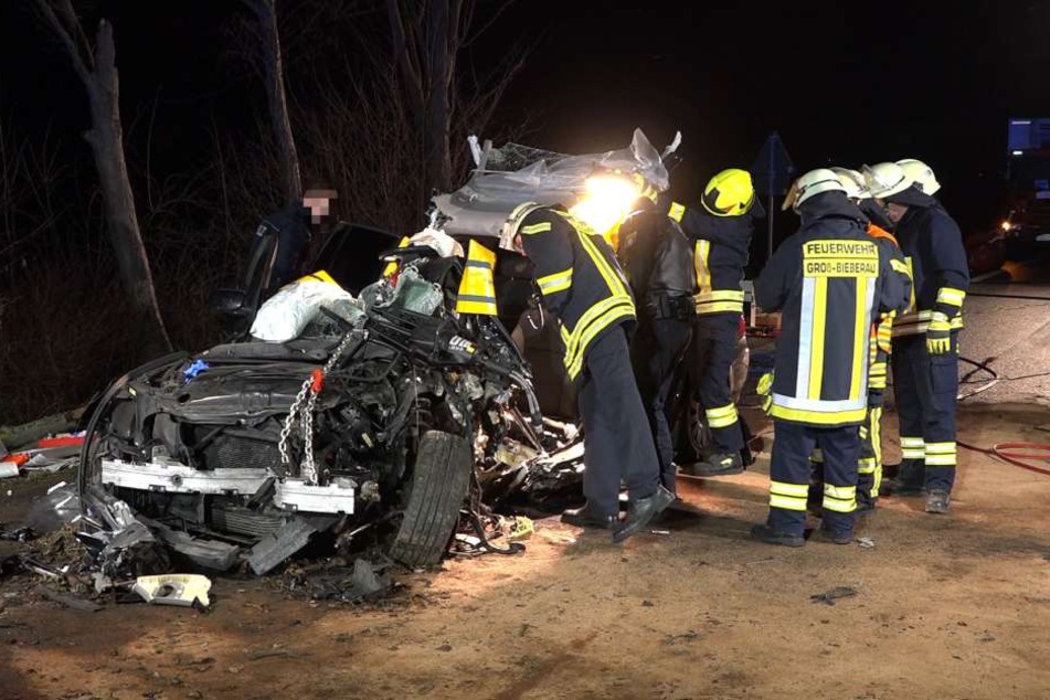 Die Feuerwehrleute untersuchen den Unfallwagen auf der B38.
