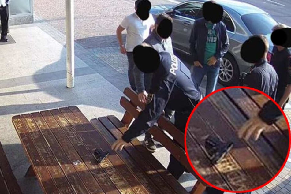 Die Schusswaffe des falschen Polizisten wird von der "echten" Polizei sichergestellt.