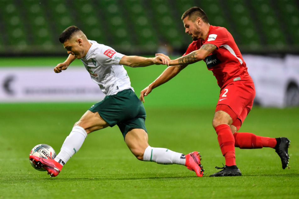 Bremens Milot Rashica (l) behauptet gegen Heidenheims Marnon Busch den Ball.