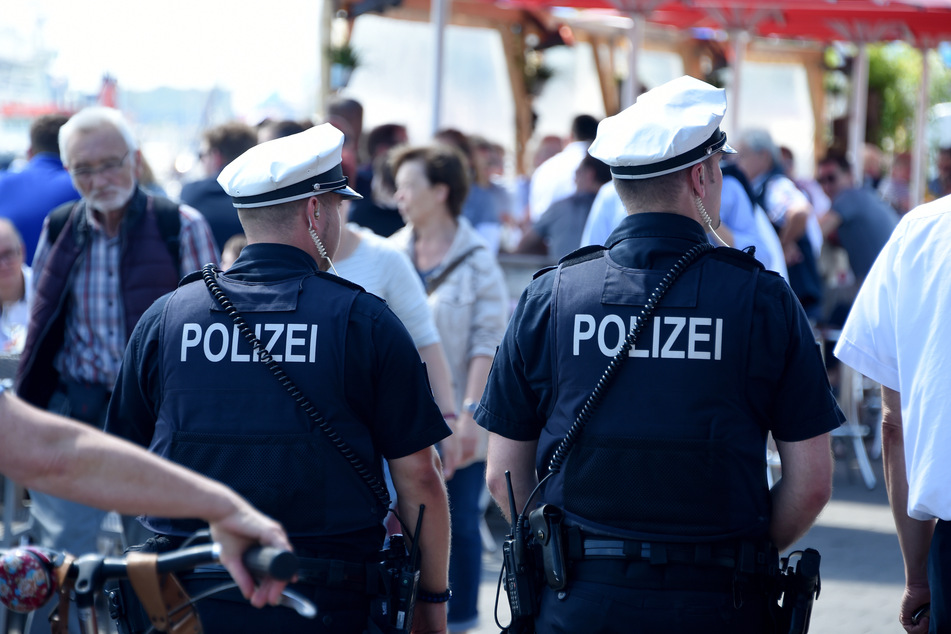 Zwei Polizisten gehen durch die Menschenmenge bei der Kieler Woche. (Symbolbild)