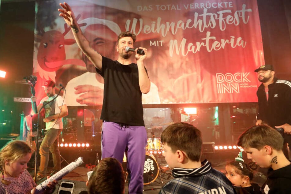 Marteria steht bei dem Weihnachtsfest mit Kindern und Jugendlichen in Rostock auf der Bühne.