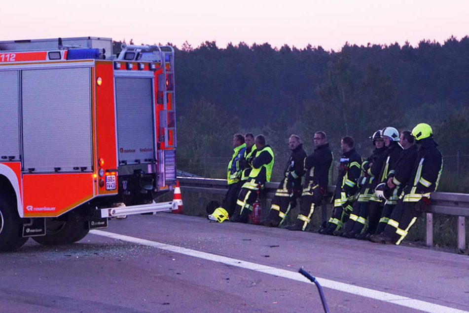 Die geschockten Kollegen sitzen trauernd an der Leitplanke.