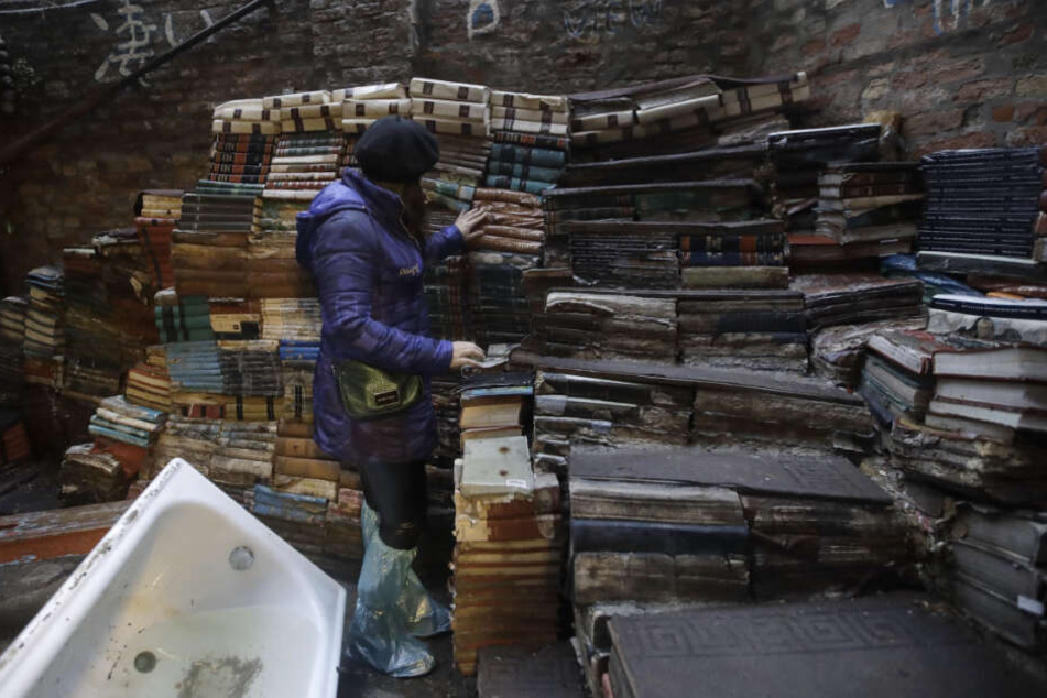 Eine junge Frau überprüft den Zustand von Büchern aus der renommierten Buchhandlung "Acqua Alta" (Hochwasser).