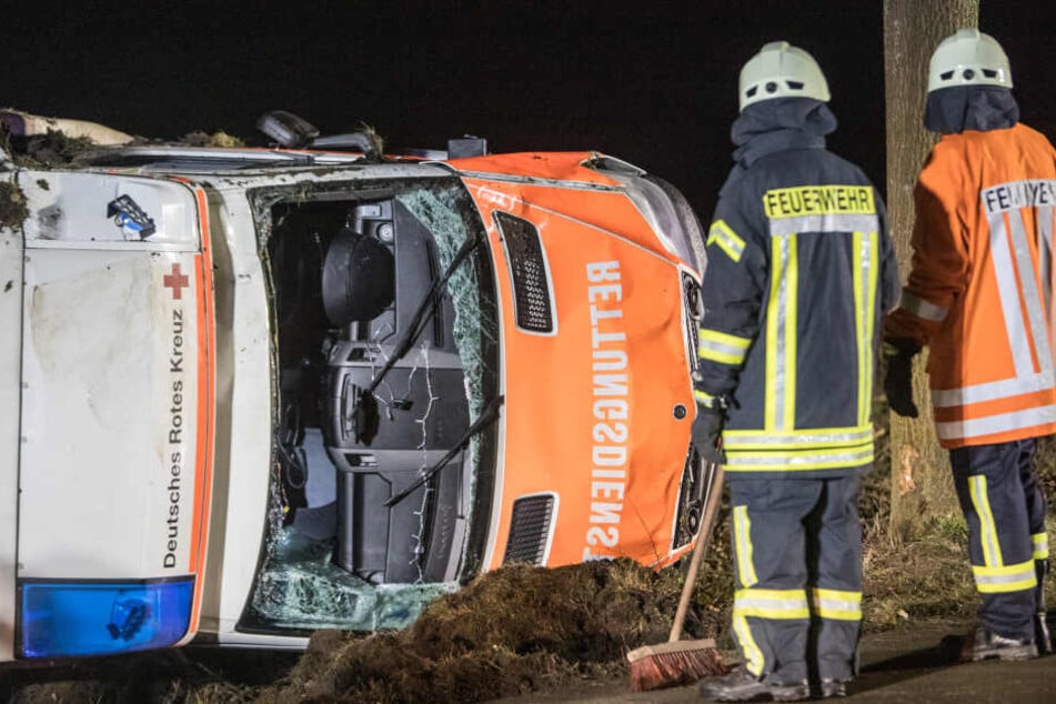 Feuerwehrkräfte stehen vor dem verunfallten Rettungswagen.