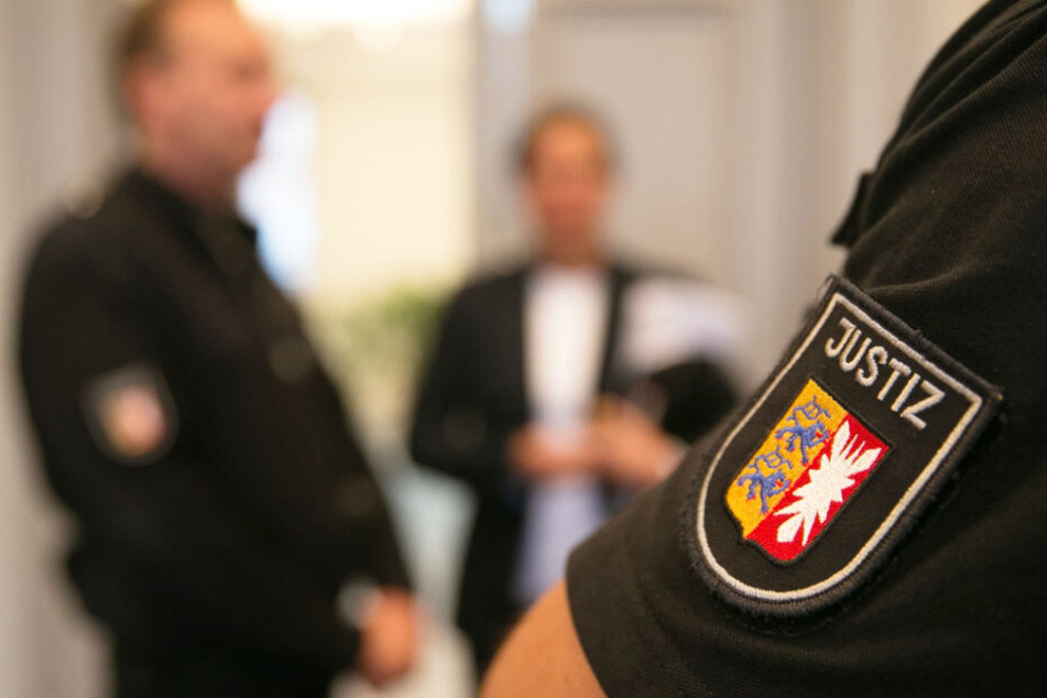 Ein Justizbeamter passt im Gerichtssaal auf. (Symbolbild)