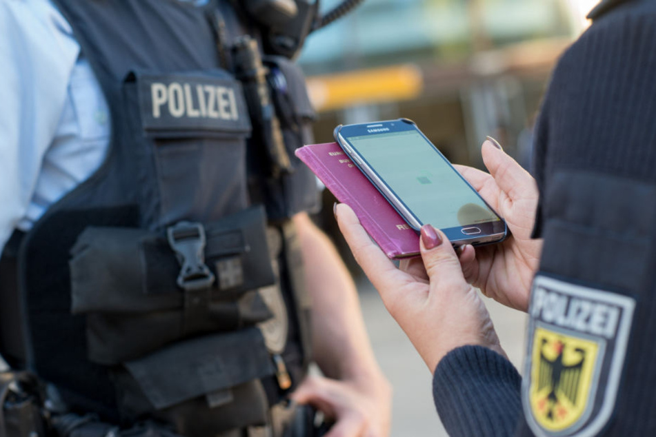 Eine Bundespolizistin scannt mit einem Mobiltelefon einen Reisepass. Die Smartphone-Fahndung wird von der Bundespolizei derzeit getestet.