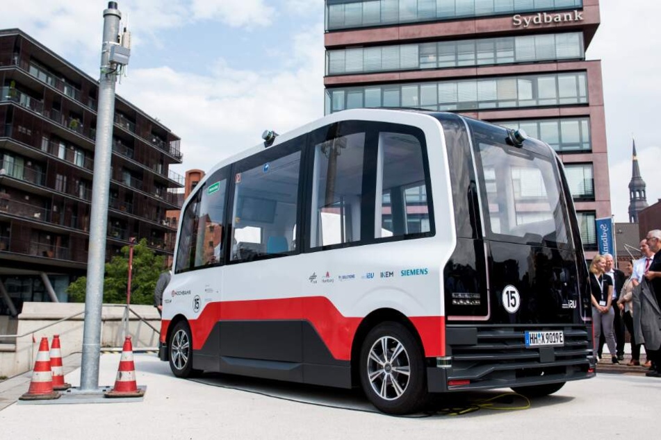 Ein Elektro-Kleinbus der Hamburger Hochbahn steht neben einer Datensäule in der HafenCity.
