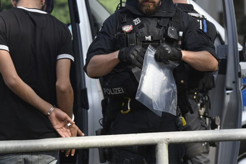 Ein Polizist hält einen Teil der beschlagnahmten "Ware" in der Hand.