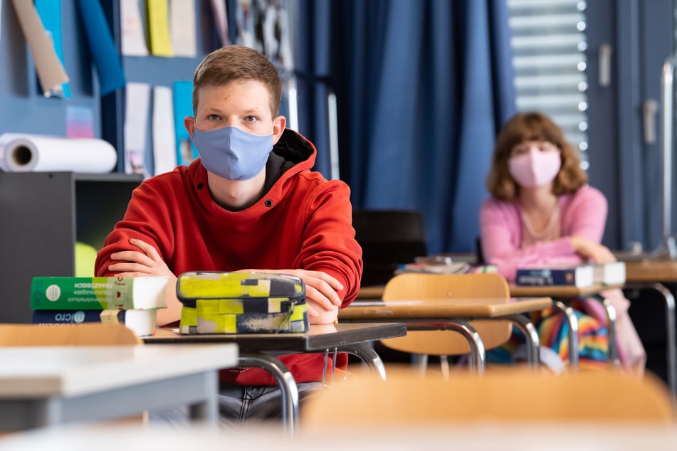 Schüler und Schülerinnen nehmen am Unterricht teil und tragen Mundschutze.