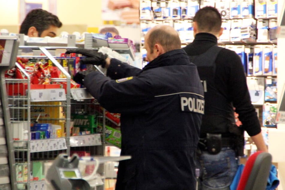 Polizisten durchsuchen einen Drogeriemarkt. (Symbolbild)