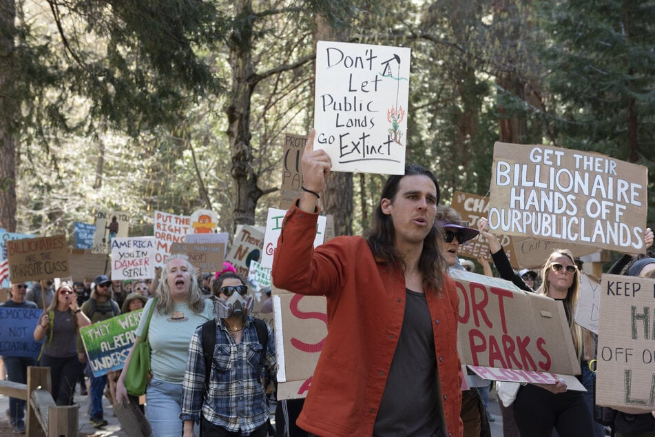 Alex Wild (c.), a former National Park Service ranger who was fired on February 14, 2025, demonstrates during a protest against federal employee layoffs at Yosemite National Park on March 1, 2025.