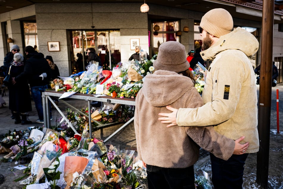 Menschen erweisen den Opfern der Silvesterfeier in Crans-Montana, Schweiz, mit Blumen die letzte Ehre.