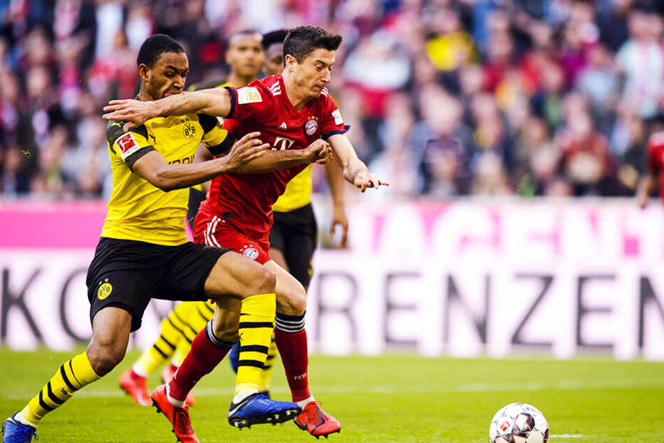 Bayerns Stürmer Robert Lewandowski setzt sich gegen BVB-Abwehrspieler Abdou Diallo durch.