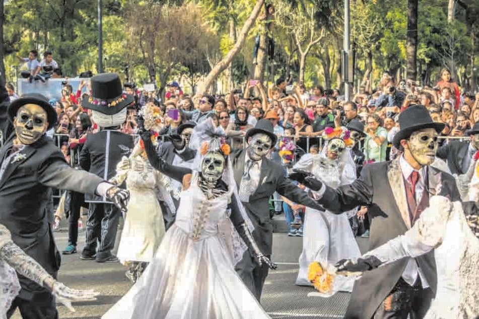 Geweint wird hier nicht: In Mexiko ist der Tag der Toten einer der wichtigsten Feiertage. In Mexiko City gibt es eine große Straßenparade mit Skeletten und dem Sensenmann.