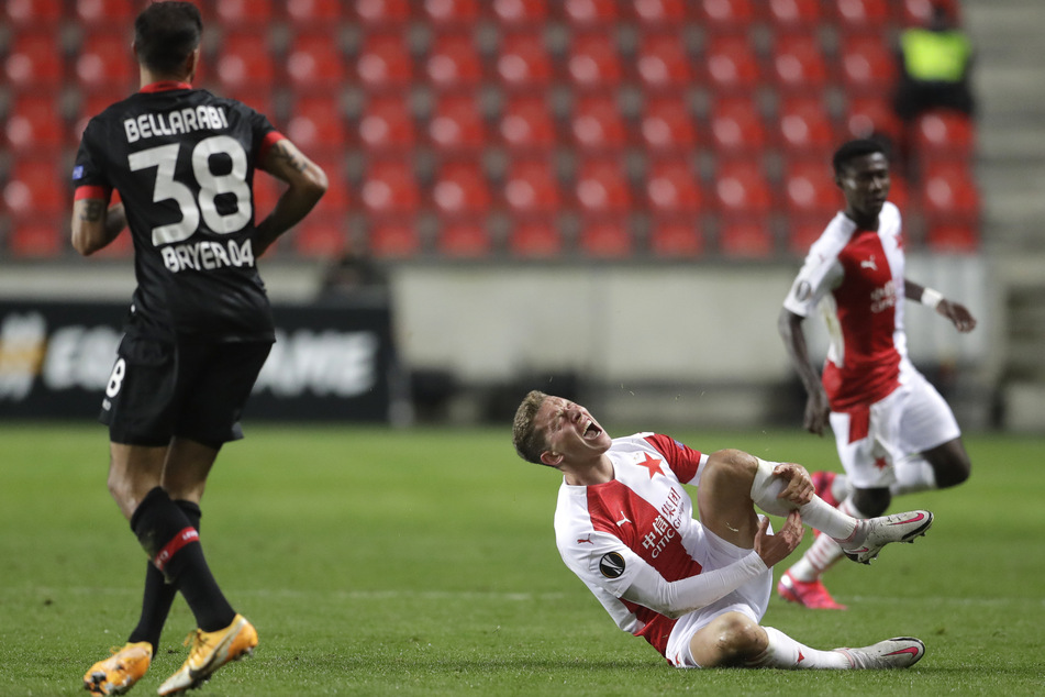 Slavias Lukas Provod (r) hält sich nach einem Foul von Leverkusens Karim Bellarabi das Schienbein.