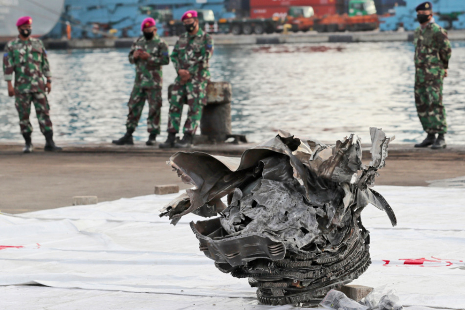 Indonesische Marinesoldaten betrachten ein Trümmerteil, das aus den Gewässern vor der Insel Java geborgen wurde.