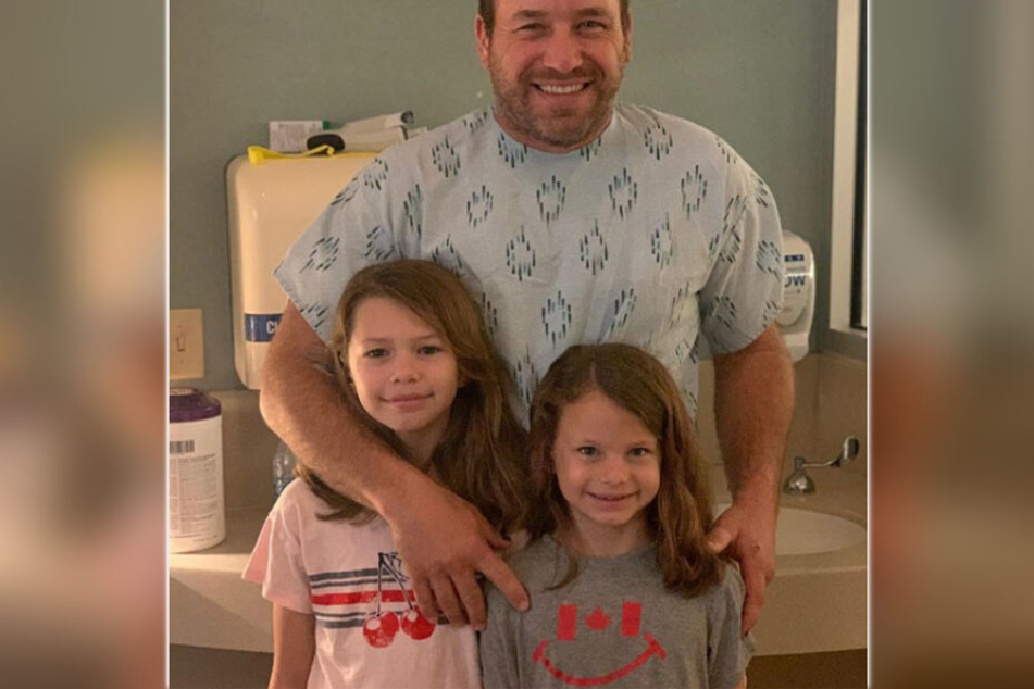 Freudestrahlend hält Ryan Newman seine beiden Töchter in den Armen.