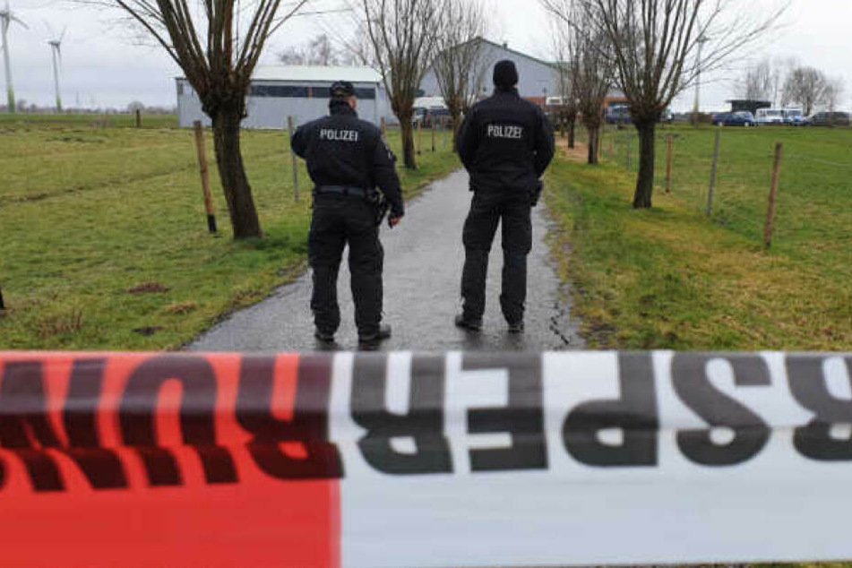 Polizisten sperren den Bauernhof in Dammfleth während der Durchsuchung ab.