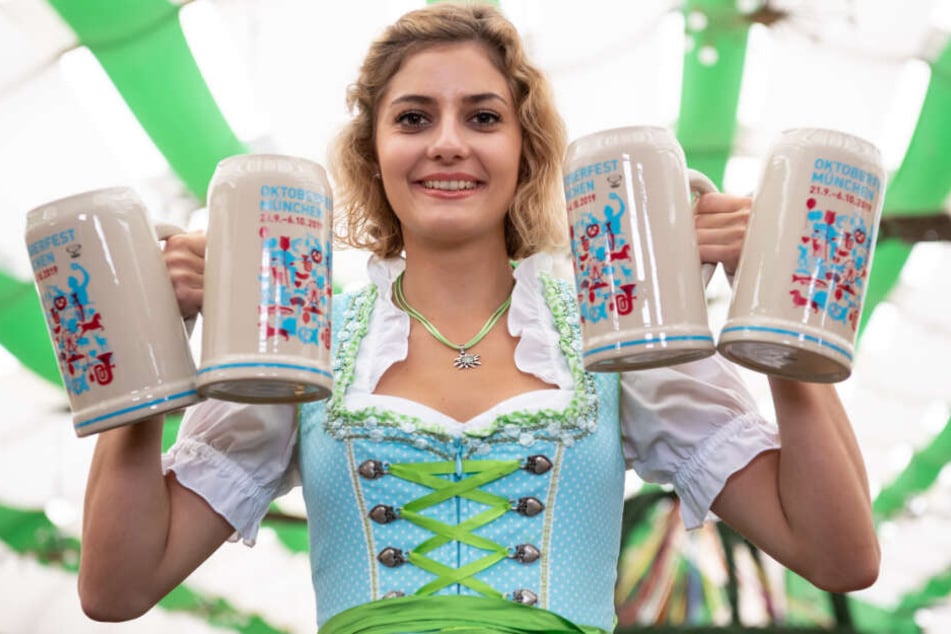 Elena Weidlich präsentiert im Armbrustschützenzelt auf dem Oktoberfestgelände den offiziellen Wiesn-Maßkrug 2019.